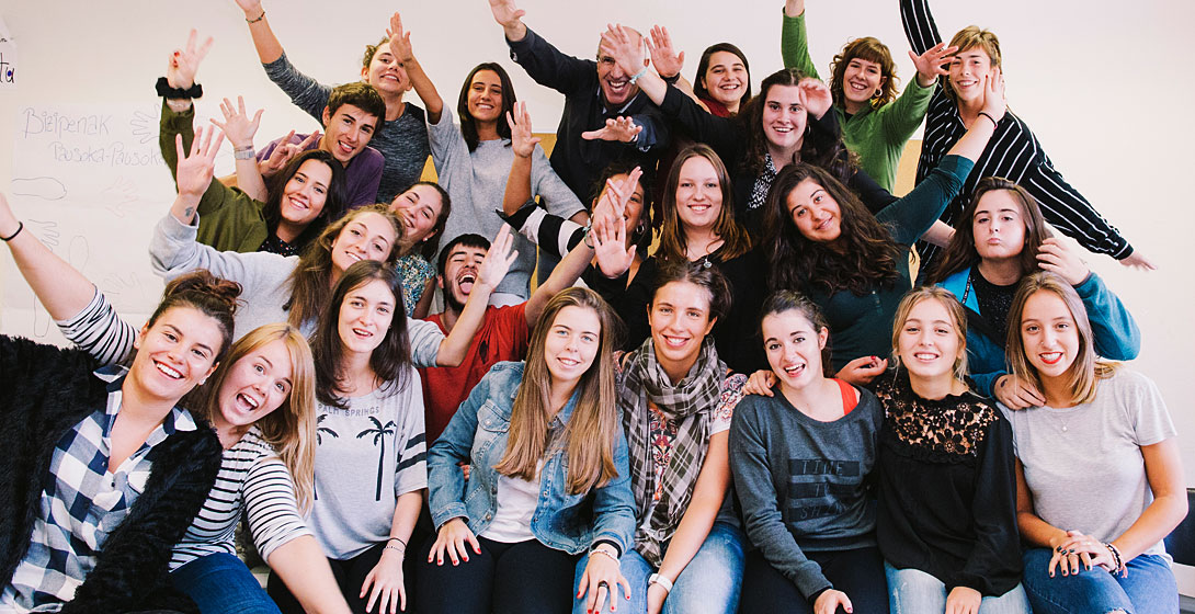 Jóvenes estudiantes de Mondragon Unibertsitatea en grupo con brazos abiertos